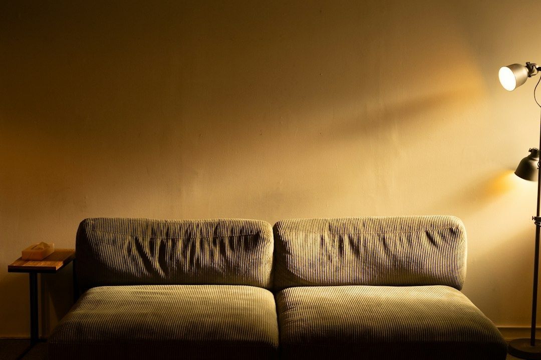 Soffa i ribbad textil med varmt ljus från två golvlampor